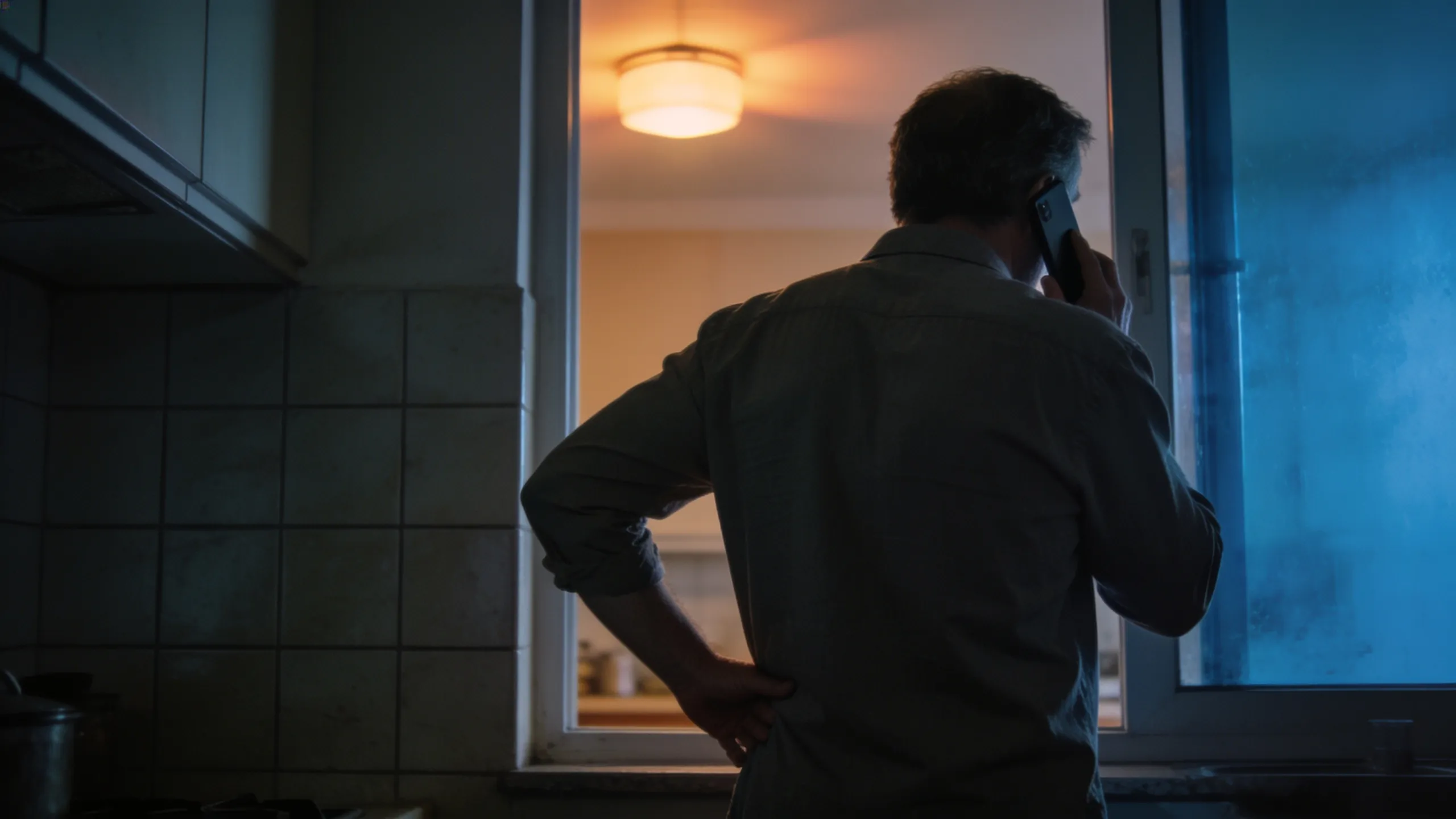 Abends zu Hause, eine Person steht von hinten am Fenster